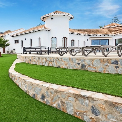 a long artificial turf strip inside a brick patio