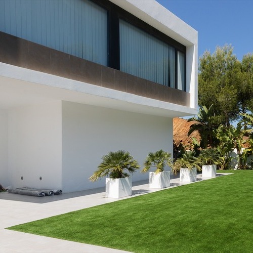 a home surrounded by a vibrant artificial turf lawn