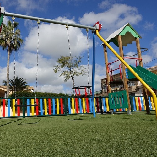 a playground covered in vibrant green artificial turf